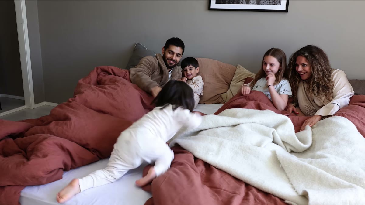 Familj som myser i en säng, från en reklamfilm