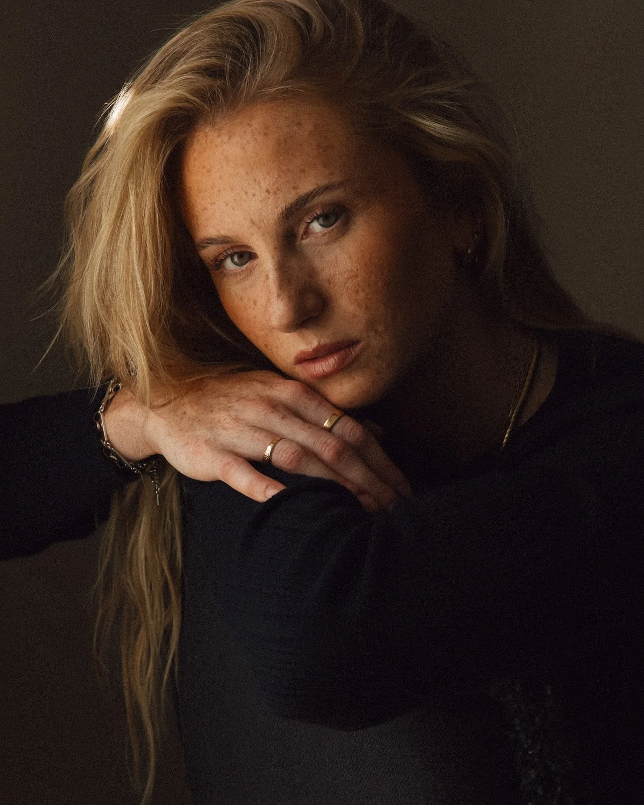 Porträtt kvinna med fräknar i mörk studio