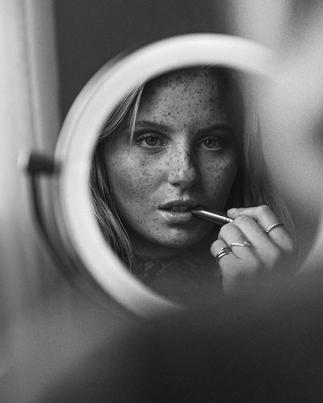 Svartvitt porträtt i spegel med läppstift