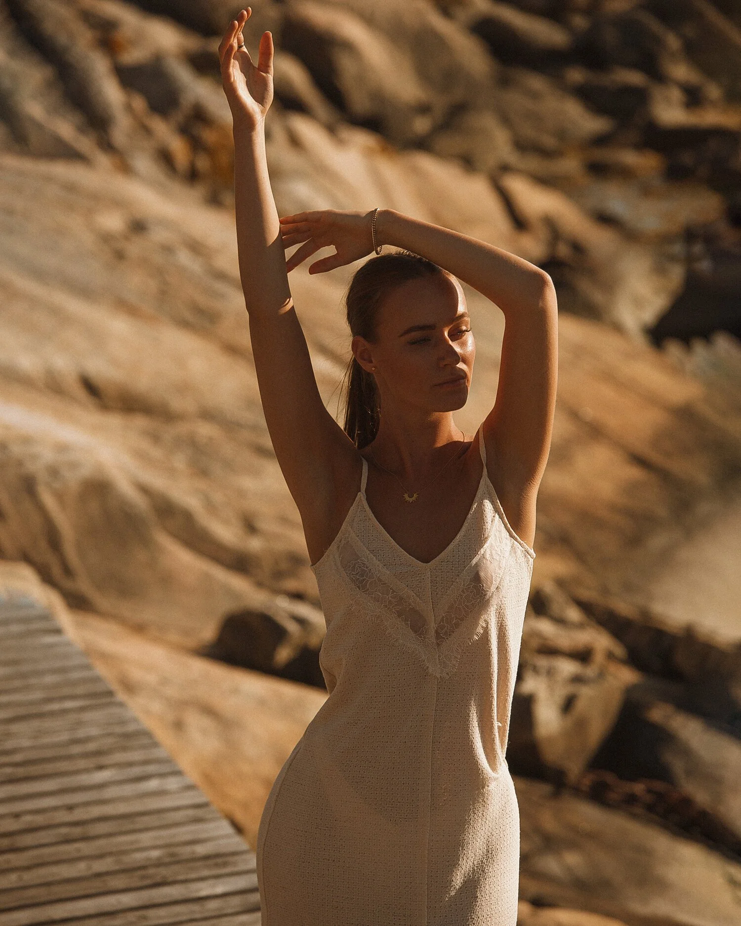 Modefoto i gyllene ljus vid klippor