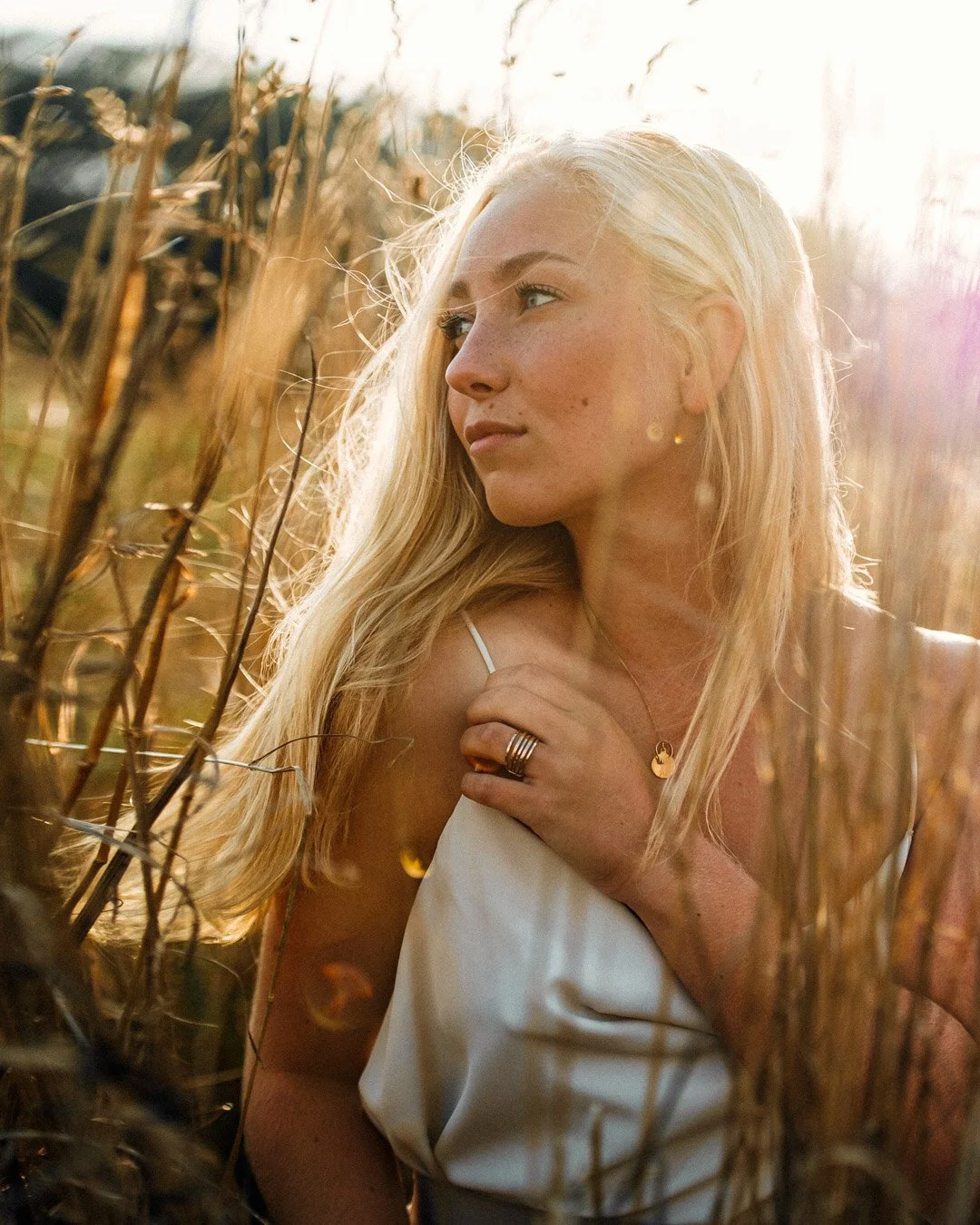 Porträtt blond kvinna i vetefält vid solnedgång