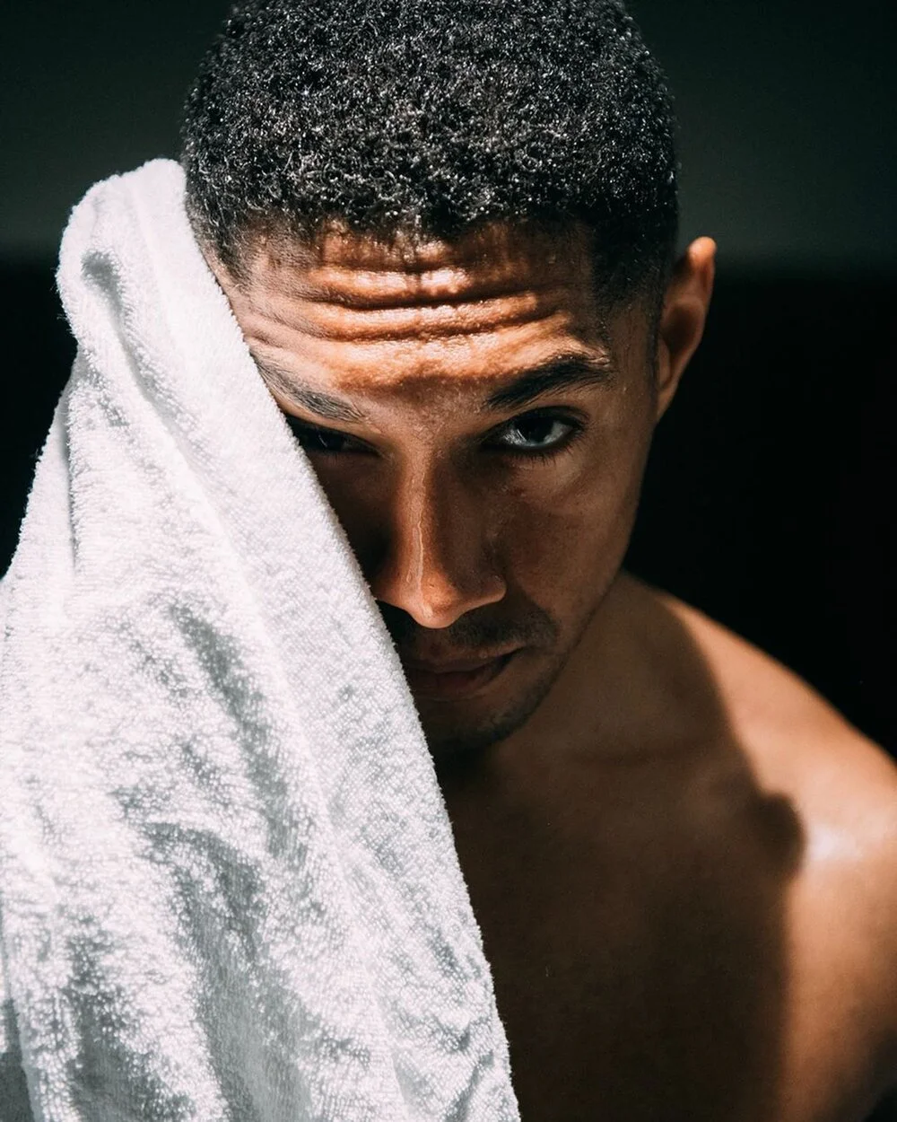 Porträtt man med handduk i dramatiskt ljus